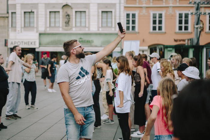 Ein Mann im Vordergrund und eine Gruppe von Kindern am Hauptplatz