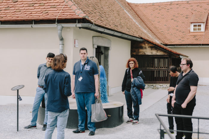 Eine Gruppe von Menschen steht im Innenhof des Graz Museum Schlossberg.