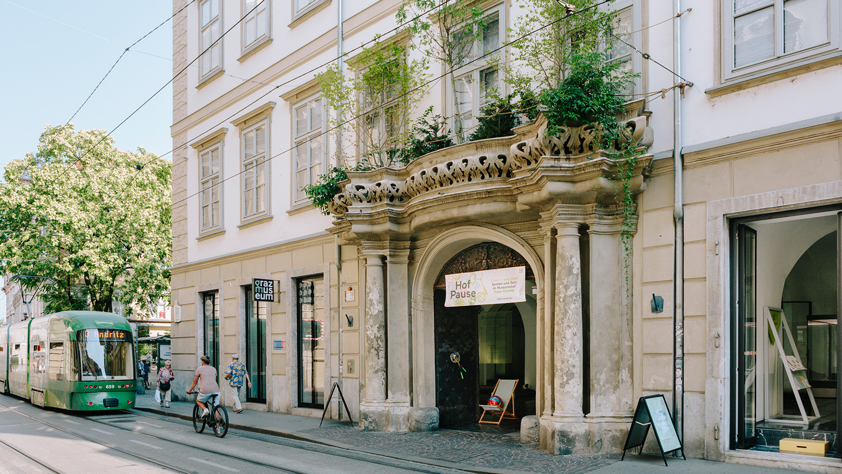 Das Eingangsportal in der Sackstraße, mit einem mit Pflanzen begrünten Balkon, direkt über dem Eingang.