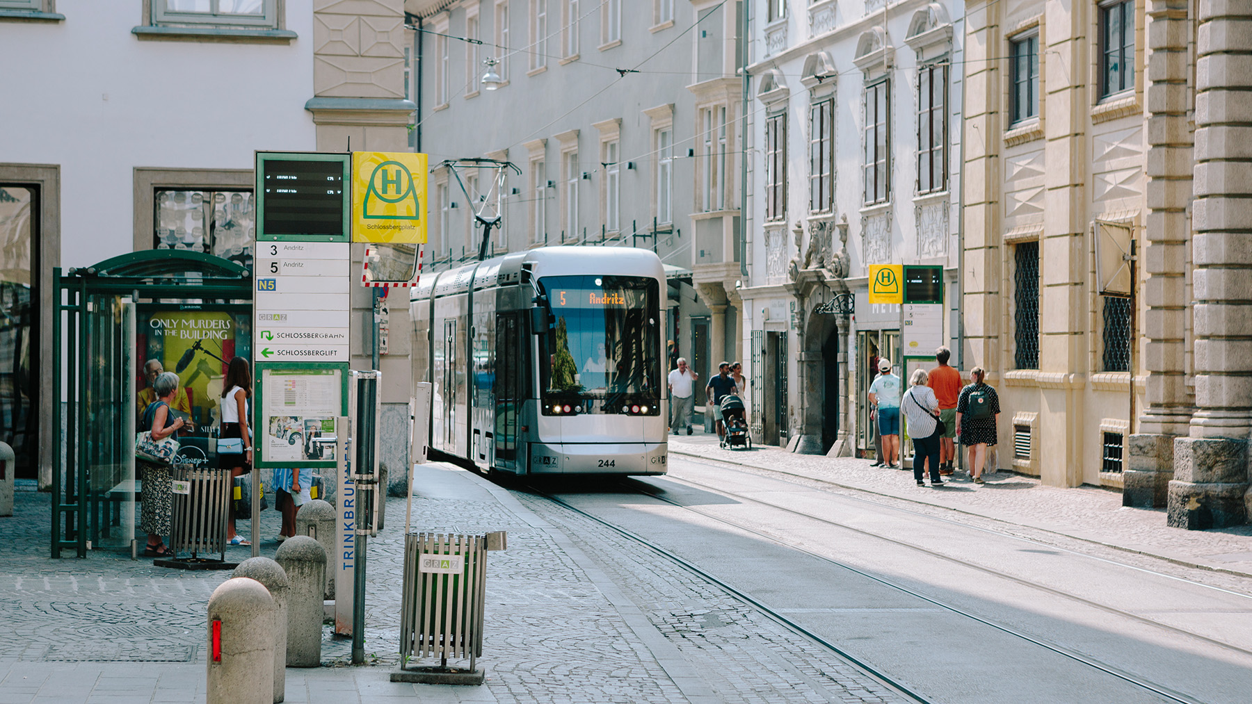 Eine Straßenbahn der Linie 5 fährt vom Hauptplatz kommend die Haltestelle Schlossbergplatz an.